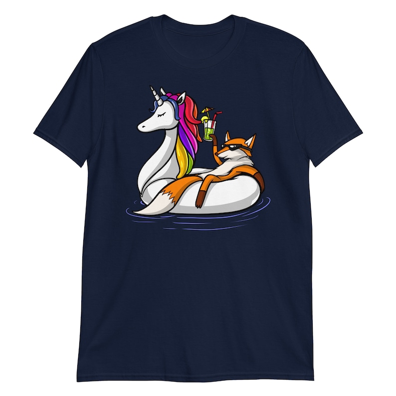 May include: A navy blue t-shirt with a graphic of a fox riding a unicorn float in a pool. The fox is holding a cocktail.