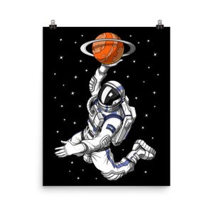 May include: An astronaut wearing a white spacesuit with blue accents is playing basketball in space. The astronaut is holding a red planet with rings around it. The background is a black starry sky.