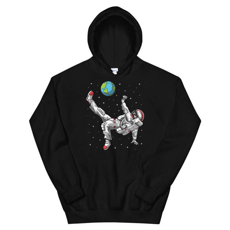 May include: Black hooded sweatshirt with a graphic of an astronaut kicking a soccer ball that is the Earth. The astronaut is wearing a white spacesuit with red accents.