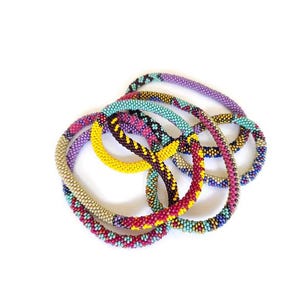 May include: A set of colorful beaded bracelets in shades of purple, pink, yellow, blue, and brown. The bracelets are made of small beads and are woven together in a intricate pattern.