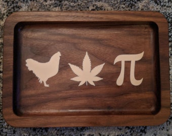 Peut inclure: Un plateau roulant en bois avec un poulet, une feuille de marijuana et le symbole pi sculptés.