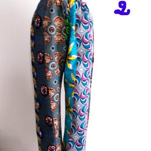 May include: A pair of colourful trousers with a patchwork design. The trousers are made of different fabrics with geometric and floral patterns in shades of blue, green, pink, and brown.