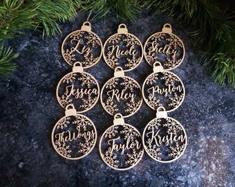 May include: Ten wooden Christmas ornaments with snowflake designs and personalized names, including Liz, Nicole, Shelby, Jessica, Riley, Payton, The Wongs, Taylor, and Kristen.