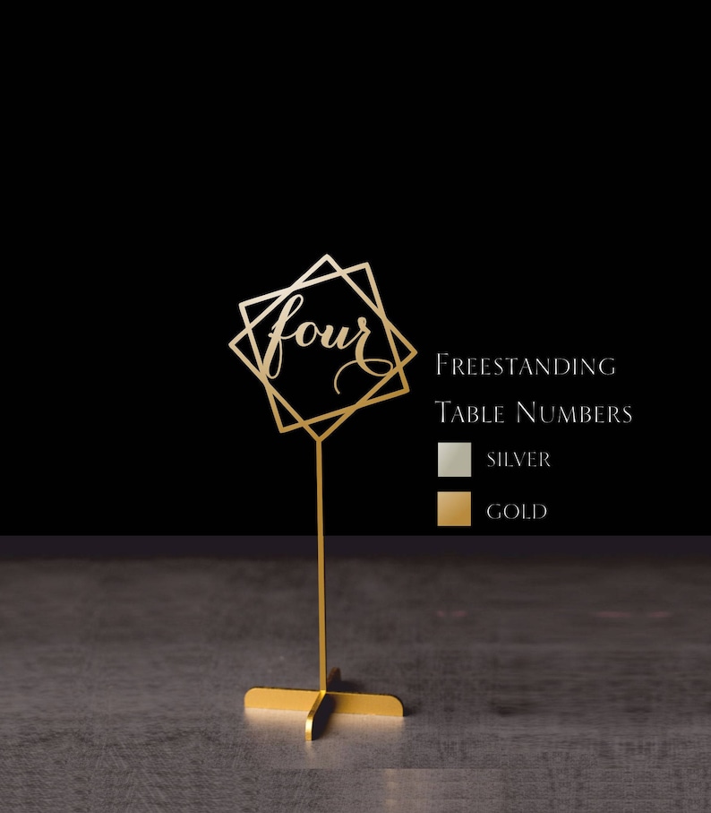 May include: Gold freestanding table number with a geometric design and the number "four" written in cursive. The table number is on a gold stand. The image also shows a color chart with the options of silver and gold.