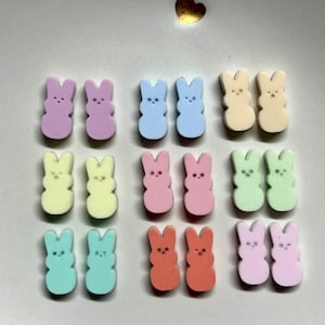 May include: A set of 10 pairs of pastel-colored bunny-shaped earrings. The earrings are made of polymer clay and come in a variety of colors, including pink, blue, yellow, green, and orange.
