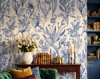 May include: A green tufted sofa with velvet pillows, a wooden console table, and a round glass coffee table. The room features blue and white floral wallpaper, a dark blue built-in bookshelf, a potted plant, and a patterned area rug.