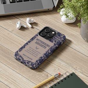 May include: A phone case with a design inspired by the classic novel "Wuthering Heights" by Emily Bront&euml;. The case features a floral pattern in shades of blue and white on a beige background. The title of the book is printed in black lettering.