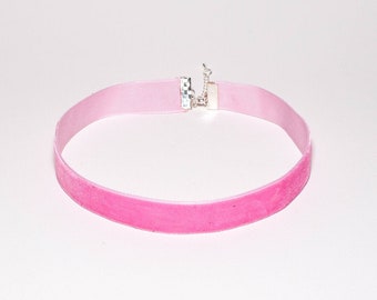 May include: A pink velvet choker with a silver clasp.