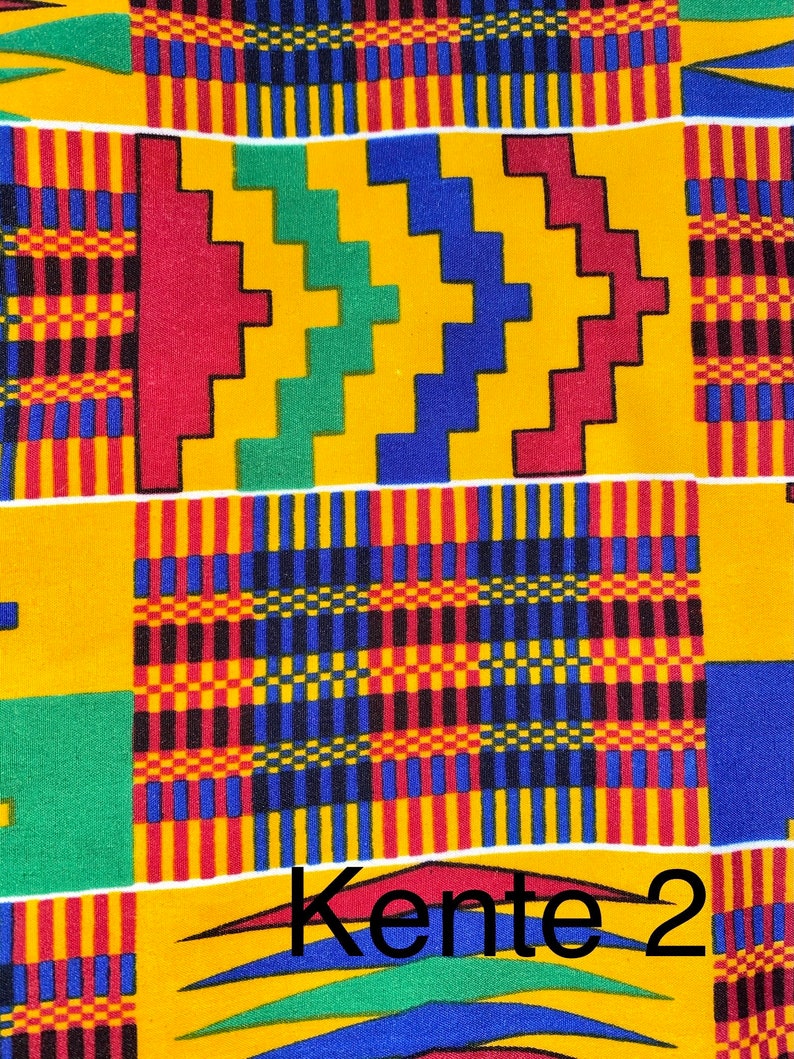Puede incluir: Un primer plano de una tela colorida con un patr&oacute;n geom&eacute;trico en tonos de amarillo, rojo, verde y azul. La tela tiene una textura tejida y se conoce como tela Kente. El texto "Kente 2" es visible en la parte inferior de la imagen.