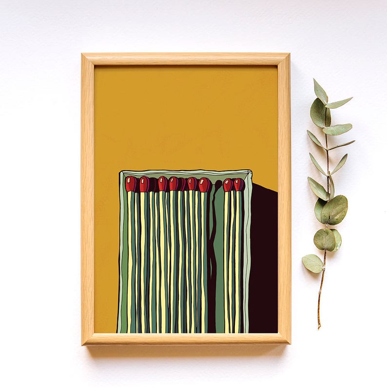 May include: A framed illustration of a box of matches with red tips and green and yellow stripes on a yellow background.