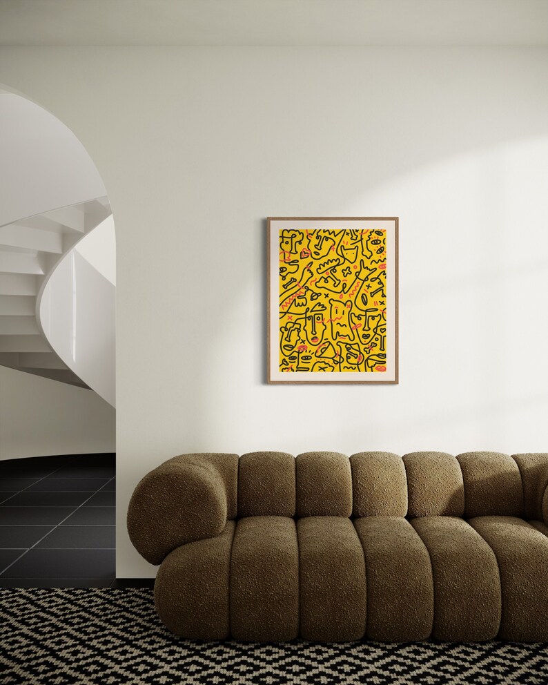 May include: A framed print of a yellow background with black and red abstract doodle art. The art features a variety of shapes and lines, including faces, circles, and squiggles.
