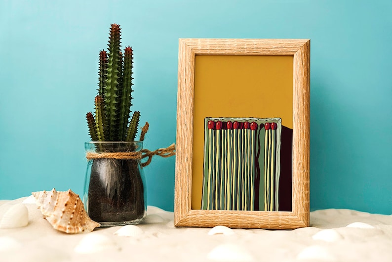 May include: A framed print of a minimalist illustration of a box of matches with red match heads. The background is a yellow color. The print is in a wooden frame.