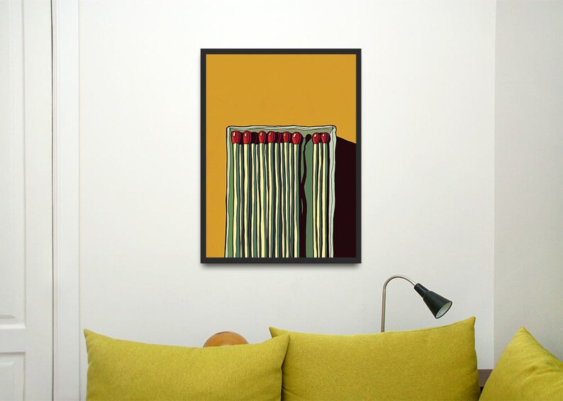 May include: A framed illustration of a box of matches with red tips on a yellow background.