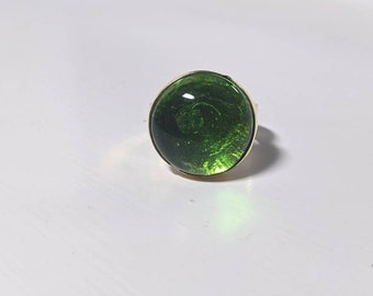 Ronde groene glazen cabochon met messing ring in V-vorm borstweringstijl