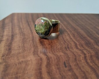 Messing 'knoopring' met ronde unakiet cabochon edelsteen 15 mm