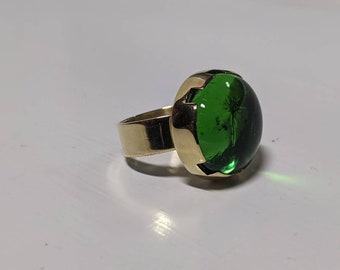 Ronde groene glazen cabochon met messing ring in borstweringstijl: