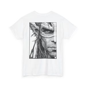 Puede incluir: Camiseta blanca con un gráfico en blanco y negro de un rostro detallado con marcas tribales y cabello largo. El gráfico está centrado en la parte delantera de la camiseta. La camiseta tiene mangas cortas y cuello redondo.