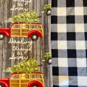 May include: A gray and white fabric with a black and white checkered pattern on the right side. The left side features a repeating pattern of a red and brown station wagon with a Christmas tree on top, and the text "Dashing through the snow".
