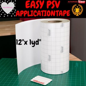Puede incluir: Un rollo de cinta de aplicación Easy-PSV blanca con un patrón de cuadrícula y el logotipo de Siser impreso en él. La cinta tiene 30,5 cm de ancho y está sobre una estera de corte verde. También se muestra un raspador de plástico blanco con el logotipo de Siser.