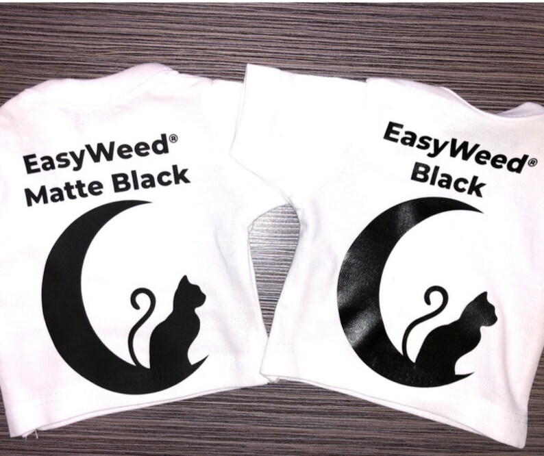 May include: Two white t-shirts with a black crescent moon and cat design. The text "EasyWeed&reg; Matte Black" is on one shirt and "EasyWeed&reg; Black" is on the other.
