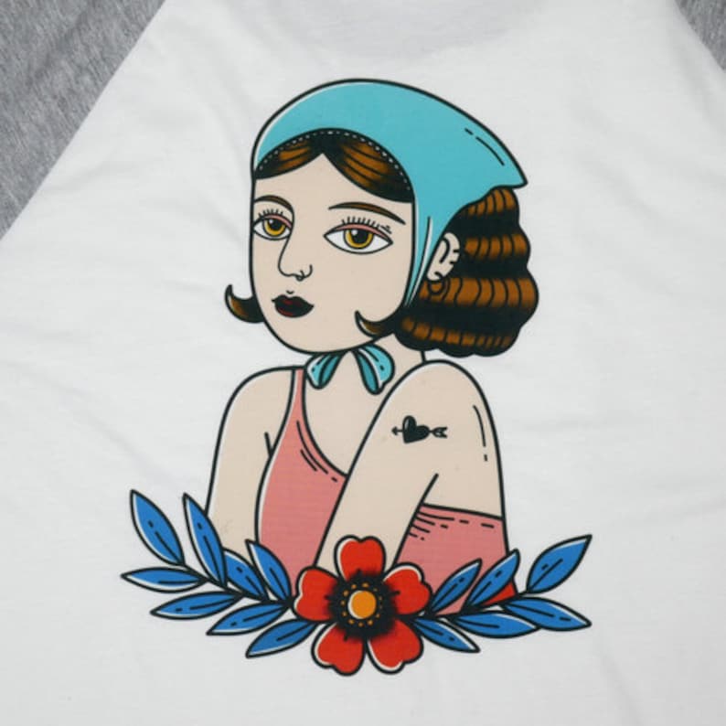 May include: A vintage-style illustration of a woman with brown hair wearing a light blue headscarf and a pink dress. She has a heart and arrow tattoo on her arm. The illustration is surrounded by blue and green leaves and a red flower.