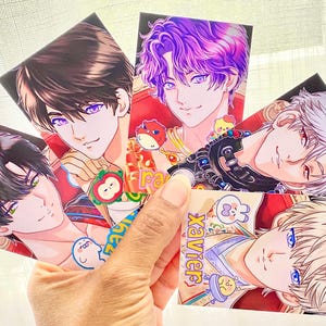 Könnte beinhalten: Eine Hand hält fünf Kunstkarten im Anime-Stil mit männlichen Charakteren mit verschiedenen Haar- und Augenfarben. Die Karten haben farbenfrohe Illustrationen, und der Name "Xavier" ist auf einer Karte zu sehen.