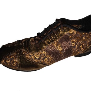 May include: A pair of brown and gold dance shoes with a lace-up fastening and a patterned design.