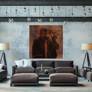 May include: A painting of a couple in a modern living room setting. The painting features a man and a woman in a vintage style, with the text "People call us loners because we like cool go to" written on the painting.