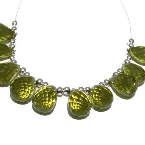 May include: A strand of green gemstone beads, each bead is a teardrop shape, strung on a silver chain.