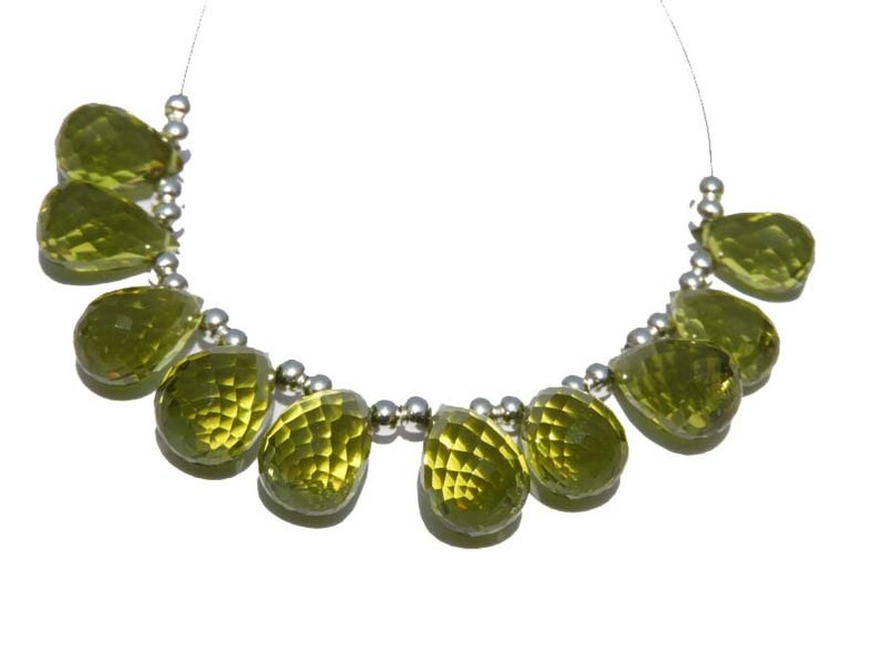 May include: A strand of green gemstone beads, each bead is a teardrop shape, strung on a silver chain.