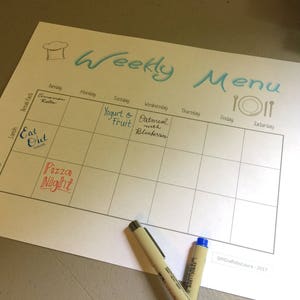 May include: A weekly menu planner with a handwritten list of meals for each day of the week. The meals include "Cinnamon Rolls", "Eat Out", "Pizza Night", "Yogurt & Fruit", "Oatmeal with Blueberries", and blank spaces for the remaining days.