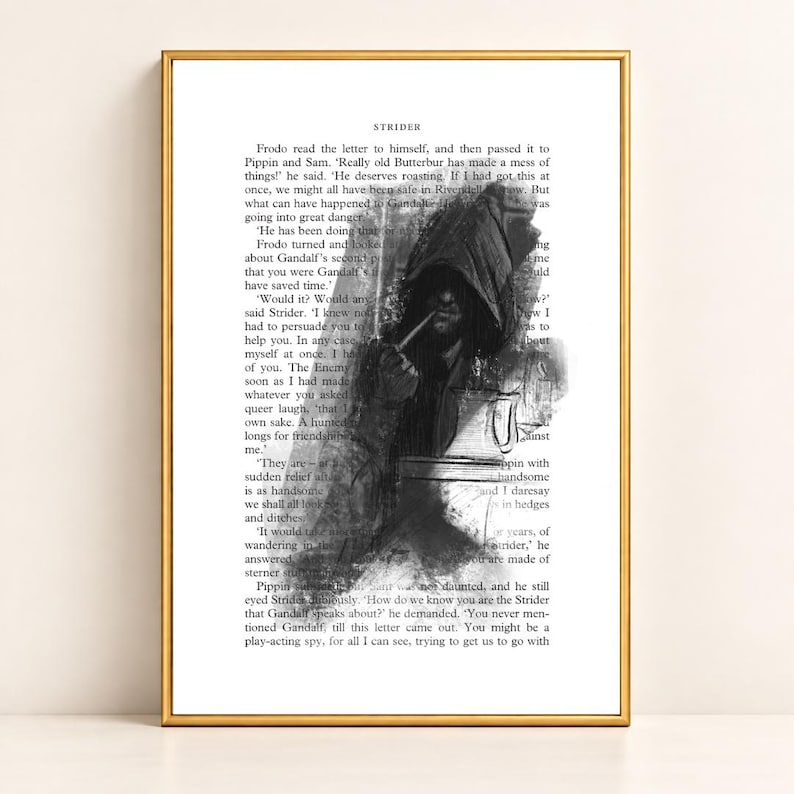 May include: A framed art print featuring a black and white charcoal-style illustration of a hooded figure smoking a pipe, overlaid on a page of printed book text titled Strider. The artwork is encased in a thin, metallic gold-colored frame.