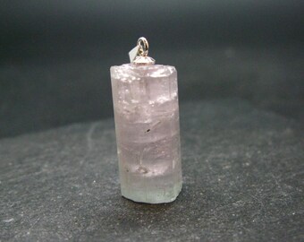 May include: A pale pink and green crystal pendant with a silver bail. The crystal is translucent and has a faceted shape.