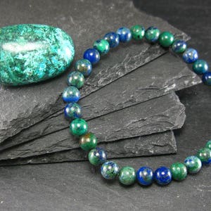 May include: A green and blue gemstone bracelet with round beads. The bracelet is made of natural stones and is a beautiful example of handcrafted jewelry.