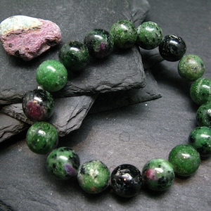 Peut inclure: Un bracelet de pierres précieuses vert et noir avec des perles rondes. Le bracelet est composé de perles de zoïsite verte et d'onyx noir.