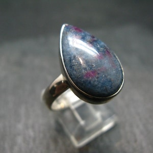 Puede incluir: Un anillo de plata con una piedra preciosa azul y rosa en forma de lágrima.