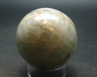 Puede incluir: Una esfera lisa de color blanco y gris con un patrón de mármol. La esfera está hecha de piedra natural y tiene un acabado pulido.