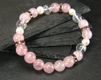 May include: A pink and clear crystal bracelet with silver accents. The bracelet is made of round beads and has a delicate, feminine look.