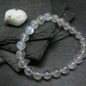 May include: A white moonstone bracelet with round beads. The bracelet is made of natural moonstone and is approximately 7 inches in length.