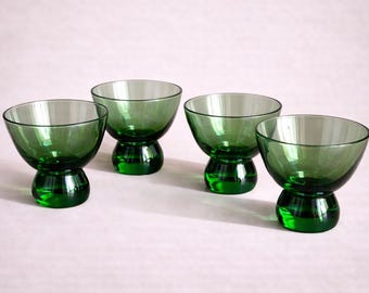 Coleção icônica de copos verdes estilo meados do século XX, com destaque para os copos de licor de fundo grosso. Copos de licor clássicos retrô na cor verde com base robusta.