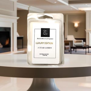 Puede incluir: Un paquete de pl&aacute;stico transparente que contiene un ambientador de cera blanco con el texto "LUXURY EDITION 5 STAR LOBBY". El producto est&aacute; sobre una mesa blanca en una habitaci&oacute;n luminosa.