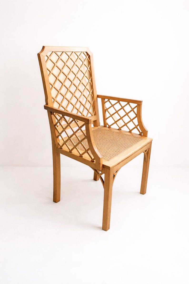 A wooden chair with a woven cane seat and a diamond-shaped lattice back. The chair is light brown and has a simple, elegant design.