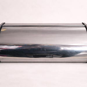 May include: A handmade wooden sign with the text "Welcome" in a playful font. The sign features a distressed white background and a dark stained wooden frame. A decorative floral element is in the corner.