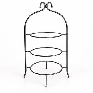 May include: A three-tiered black metal display stand featuring a curved arched top with a decorative loop handle. The structure consists of three circular rings supported by a vertical frame with four legs, providing a stable base for items.