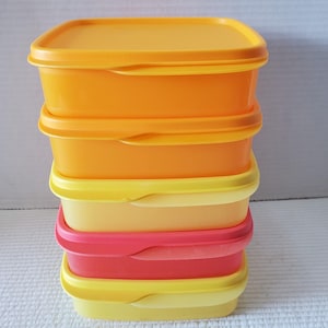 May include: A stack of five colourful plastic food storage containers. The containers are rectangular with matching lids. Colours include orange, yellow, and pink. The containers are designed for food storage and organisation.