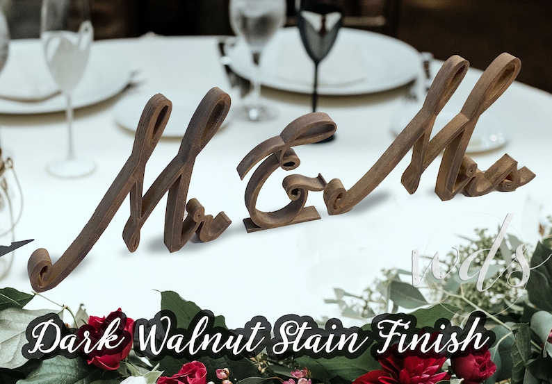 May include: Wooden "Mr & Mrs" wedding sign with a dark walnut stain finish. The sign is made of two separate pieces, one for "Mr" and one for "Mrs".