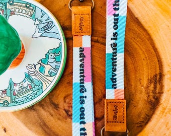 La aventura está ahí fuera. Cordón de muñeca / Llavero / Adorno para bolso / Accesorio para parques temáticos / Mochila, bolso, riñonera, bolsita.