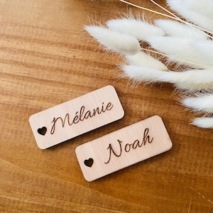 Hölzerner Hochzeits-Platzmarker, personalisierbar mit dem Vornamen der Gäste, eingraviert im Boho-Chic-Taufstil mit kleinem natürlichen Herzloch