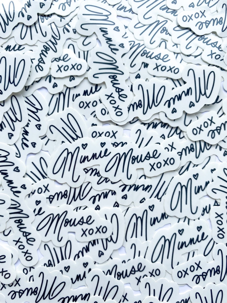 Op de afbeelding: Een close-up van een stapel witte stickers met zwarte letters. De stickers bevatten de tekst "Minnie Mouse" en "XOXO".