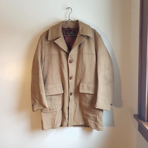 Könnte beinhalten: Eine braune Wildlederjacke mit kariertem Futter und einem braunen Lederetikett mit der Aufschrift "Chadwicks of Boston".